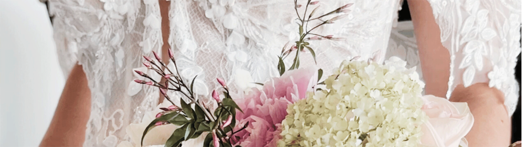 Close-up of a bride holding a bouquet from Justine’s Florals while wearing an ivory wedding dress at Bliss Bridal Salon in Fort Worth